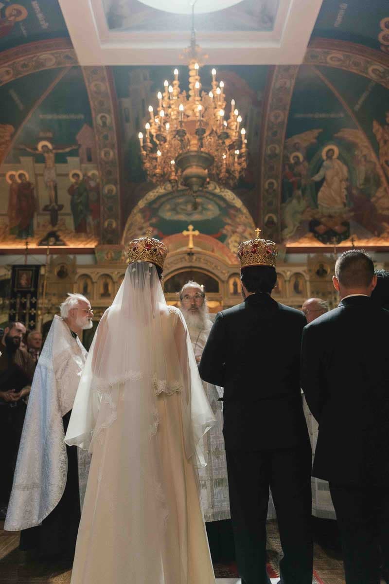 Marianna and Paul sharing a joyful moment at their Russian Orthodox wedding ceremony